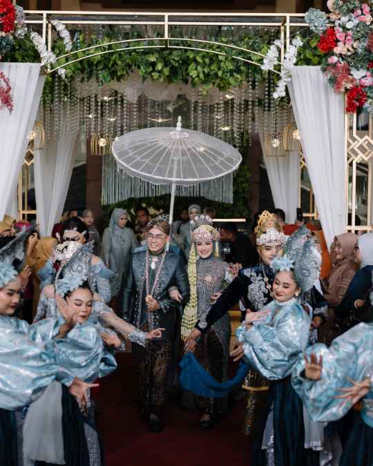 Pasangan pengantin menikmati perayaan bersama tamu